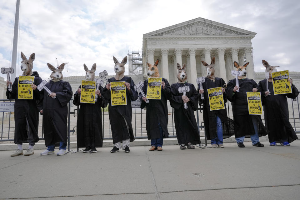 Demonstrators stand outside the Supreme Court as the justices prepare to hear arguments over whether Donald Trump is immune from prosecution in a case charging him with plotting to overturn the results of the 2020 presidential election, on Capitol Hill Thursday, April 25, 2024, in Washington. (AP Photo/Mariam Zuhaib)