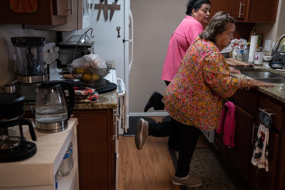 Marlene Carrasca (izq.) ayuda a Carmen García a hacer ejercicio en su apartamento de Phoenix, el 6 de septiembre de 2023.