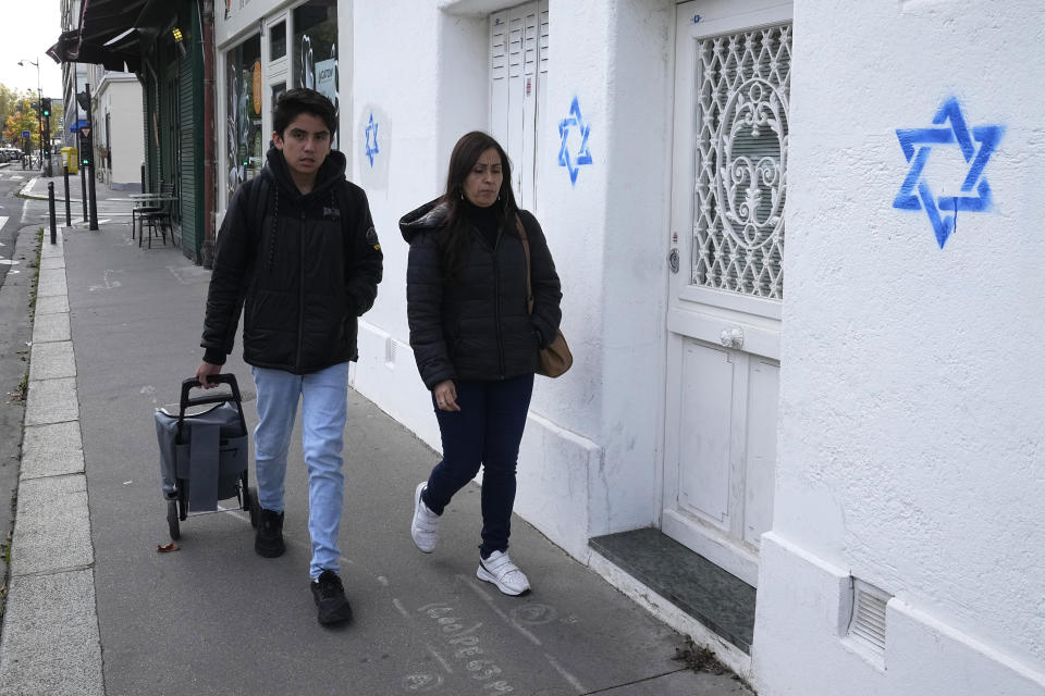 People walk by Stars of David tagged on a wall Tuesday, Oct. 31, 2023 in Paris. Paris police chief Laurent Nunez described the graffiti as anti-Semitic and said police are investigating. (AP Photo/Michel Euler, Pool)