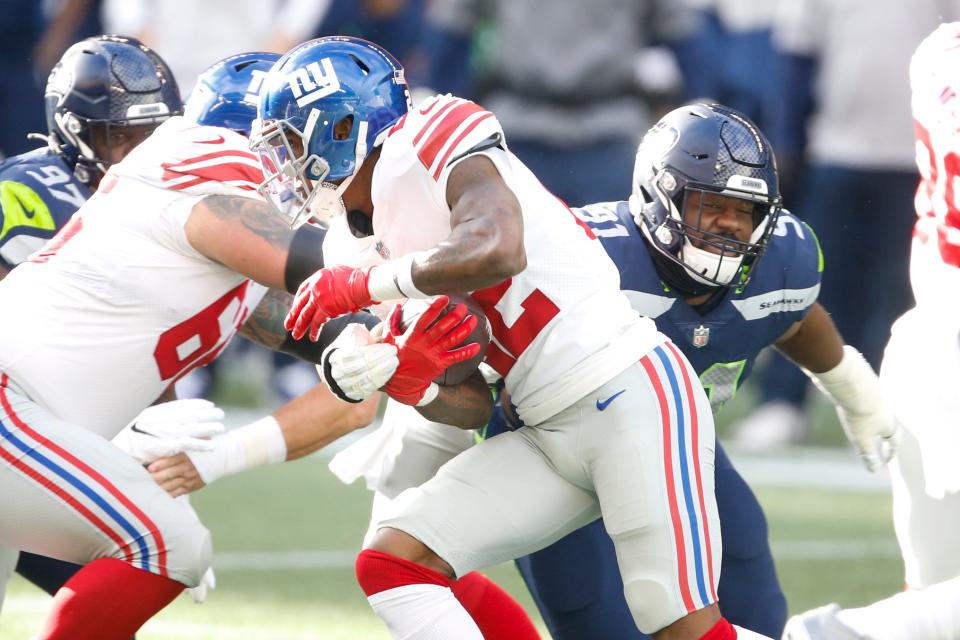 Seattle Seahawks defensive end L.J. Collier (91) tackles New York Giants running back Wayne Gallman (22) during the first quarter at Lumen Field in Seattle on Dec. 6, 2020.