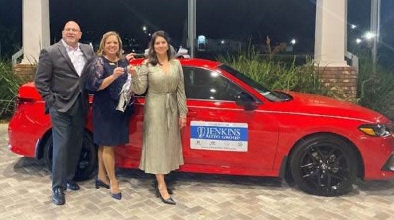 Cindy Bellamy is pictured at left with Jason Kirkland and Maria Patino from Jenkins Auto Group, getting the keys to her new Civic that she will get to drive for three years.