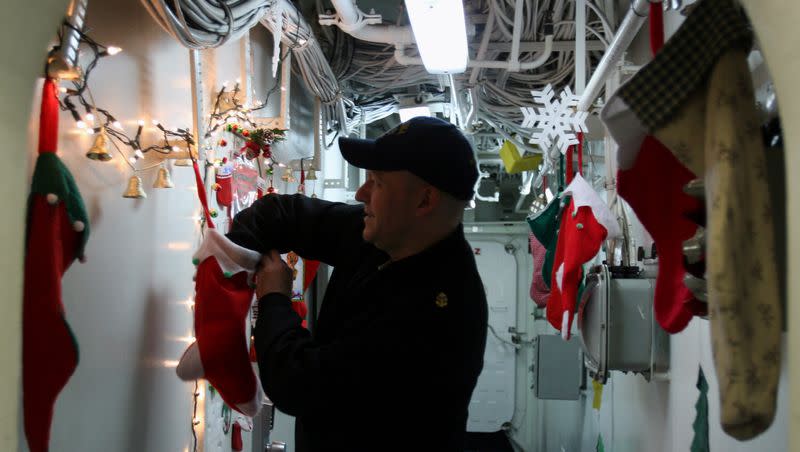 U.S. Navy Chief Petty Officer Scott Boyle, 36, of Suffolk, Virginia, reaches into a Christmas stocking Tuesday, Dec. 23, 2008.