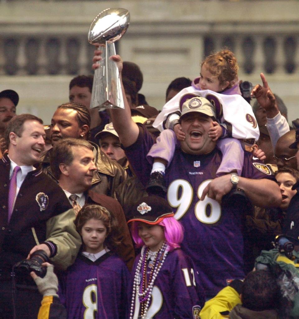 Baltimore Ravens lineman Tony Siragusa holds up the Super Bowl trophy as he carries his daughter, Samantha Rose, on his shoulders during festivities celebrating the Ravens Super Bowl victory over the New York Giants, at Baltimore's City Hall plaza Tuesday, Jan. 30, 2001. Baltimore Mayor Martin O'Malley is seen at left.  (AP Photo/Chris Gardner)