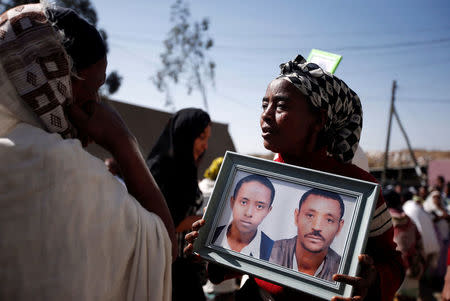 A woman carries a photograph as she mourns her family members suspected to be missing following a landslide when a mound of trash collapsed on an informal settlement at the Koshe garbage dump in Ethiopia's capital Addis Ababa, March 14, 2017. REUTERS/Tiksa Negeri