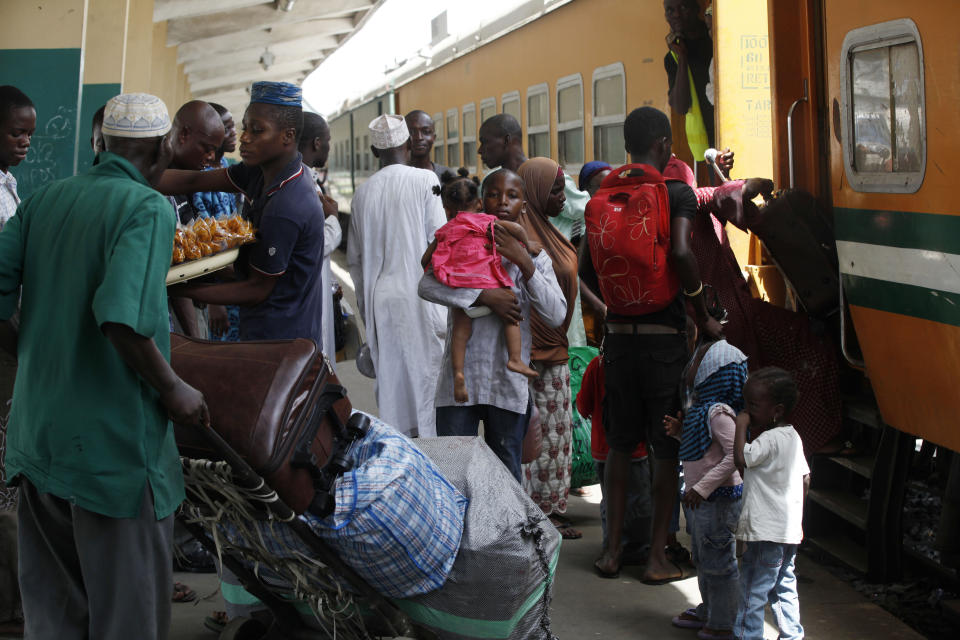 In this Photo taken, Friday, March . 8, 2013, Passengers board an Ooni of Ife train to Kano, in Lagos, Nigeria. Nigeria reopened its train line to the north Dec. 21, marking the end of a $166 million project to rebuild portions of the abandoned line washed out years earlier. The state-owned China Civil Engineering Construction Corp. rebuilt the southern portion of the line, while a Nigerian company handled the rest. (AP Photo/Sunday Alamba)