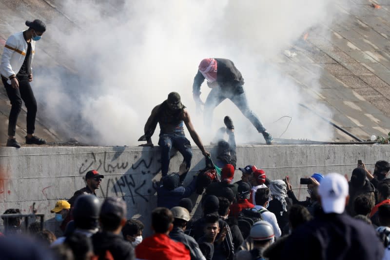 Iraqi demonstrators carry a man killed during ongoing anti-government protests, in Baghdad