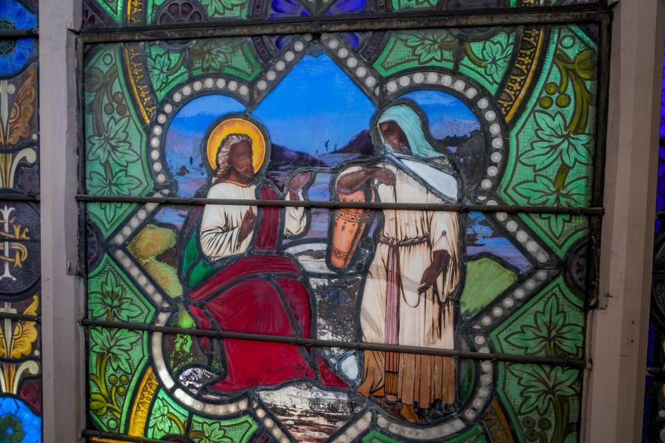 Jesus talks with a Samaritan woman in the bottom portion of the window.