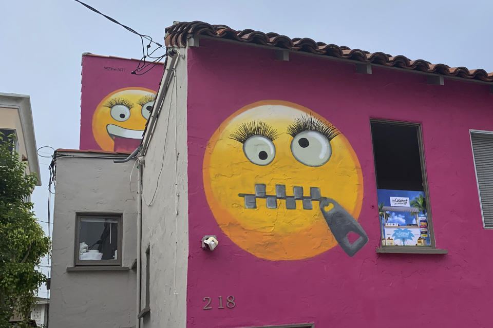 Painted emoji are seen on a house in Manhattan Beach, Calif. on Wednesday, Aug. 7, 2019. The Southern California seaside community is in an uproar after the home was given the new paint job featuring two huge emojis on a bright pink background. Manhattan Beach residents railed against the makeover during a City Council meeting Tuesday night, citing problems with spectators. (AP Photo/Natalie Rice)