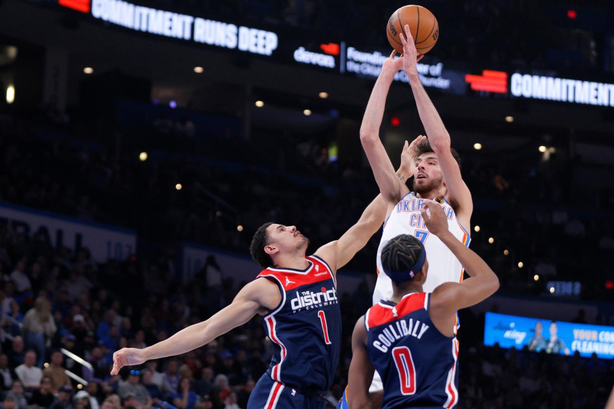 Oklahoma City Thunder forward Chet Holmgren (7) shoots over Washington Wizards guard Johnny Davis (1) and guard Bilal Coulibaly (0) during an NBA basketball game between the Oklahoma City Thunder and the Washington Wizards at Paycom Center in Oklahoma City, Friday, Feb. 23, 2024.