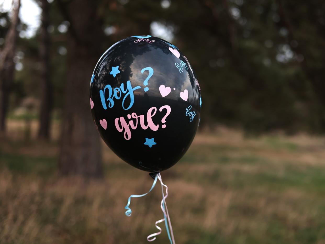 A black balloon outside with the words "boy? girl?" for a gender reveal party