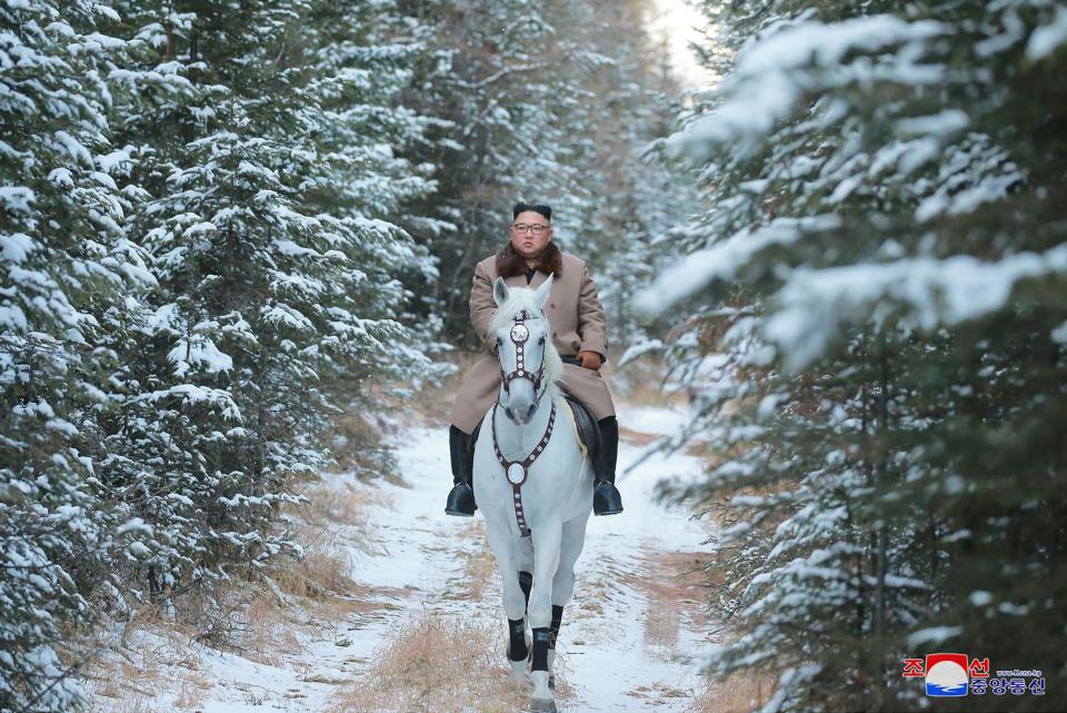 Kim Jong-un rides a horse as he climbs the mountain (AP)