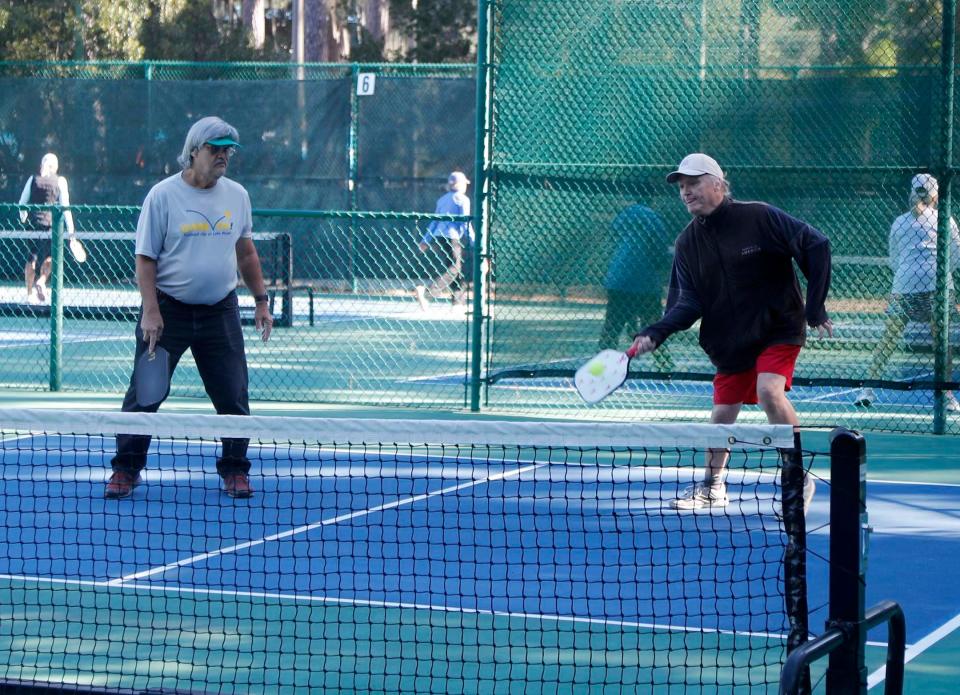 Ricky Snipes, left, and Terry Patterson play a doubles pickleball game at The Landings Club's Franklin Creek Tennis Center on Oct. 20, 2022.