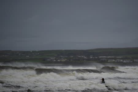 A surfer is seen on rough water in the Atlantic on the eve of storm Ophelia in an area where the tide should be out in the County Clare town of Lahinch, Ireland October 15, 2017. REUTERS/Clodagh Kilcoyne