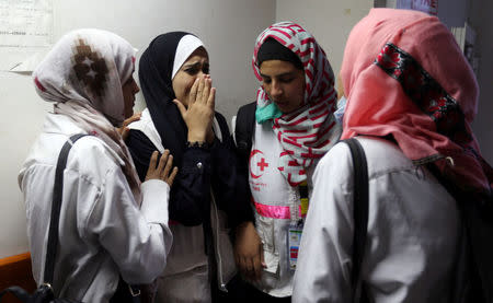 Colleagues of Palestinian nurse Razan Al-Najar, who was killed during a protest at the Israel-Gaza border, react at a hospital in the southern Gaza Strip June 1, 2018. REUTERS/Ibraheem Abu Mustafa