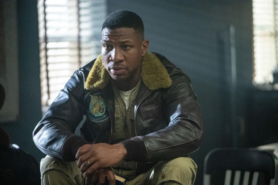 Major's character sitting in a leather jacket