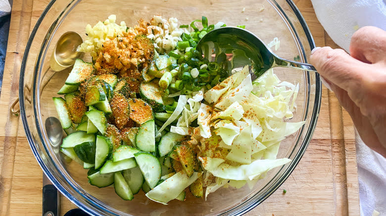 Mixing cucumber cabbage salad