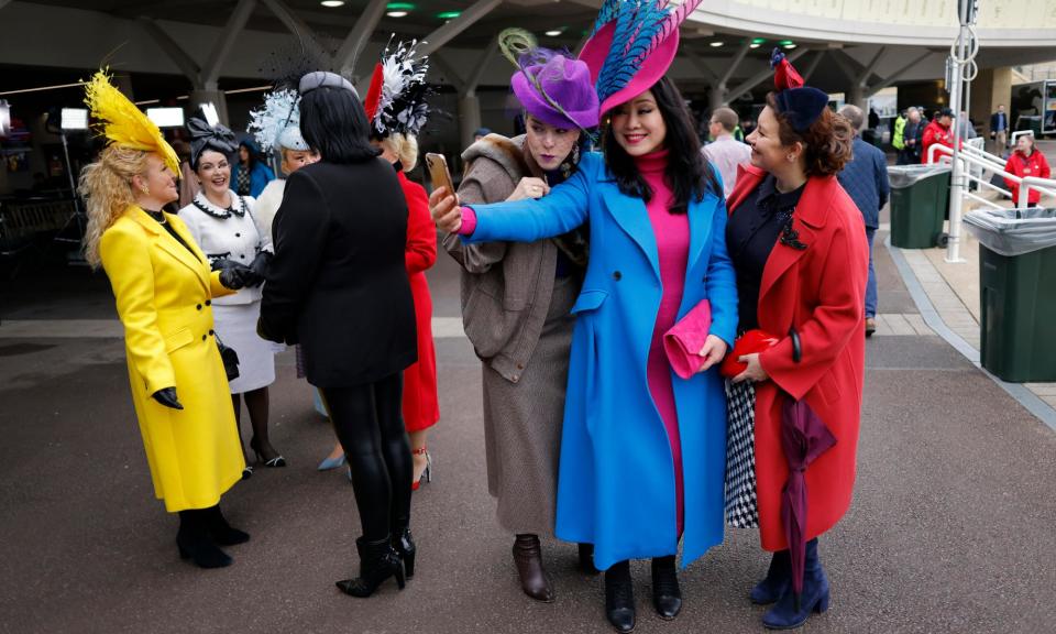 <span>Racegoers in a variety of hats before competition starts on day two of the Cheltenham Festival.</span><span>Photograph: Tom Jenkins/The Guardian</span>