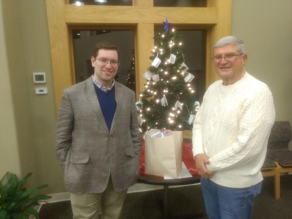 Rev. Jake Bellinghausen, left, pastor of Grace Lutheran Church in Vestal, and John Holton, a church member in charge of the veterans help program, stand in front of the giving tree, one of the numerous charitable programs the church participates in.