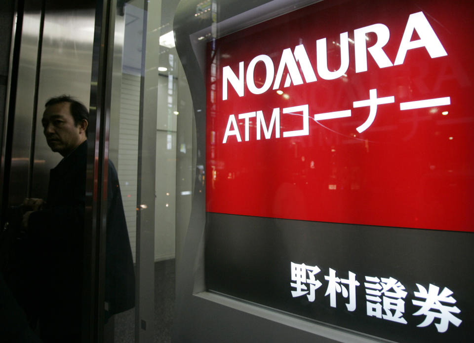 A man leaves a Nomura Securities branch in Tokyo November 19, 2008. Nomura Holdings Chief Executive Kenichi Watanabe said on Wednesday that he thought the global liquidity crisis was over but that the next problem was how to turn the real economy around.  REUTERS/Yuriko Nakao (JAPAN)