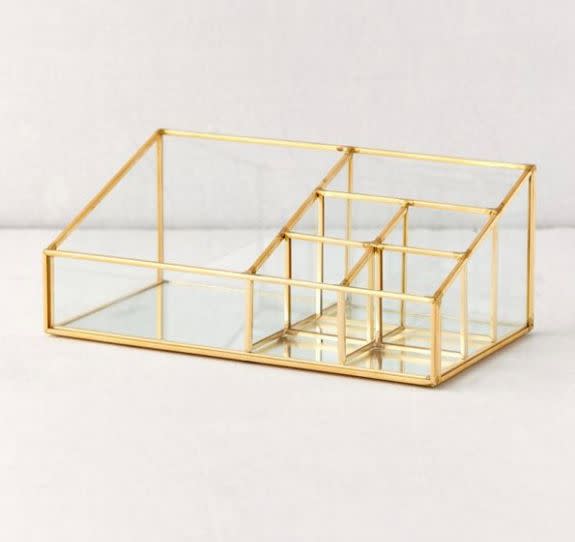 Find this gold metal and glass makeup organizer for <a href="https://fave.co/38w9ziA" target="_blank" rel="noopener noreferrer">$34 at Urban Outfitters</a>.