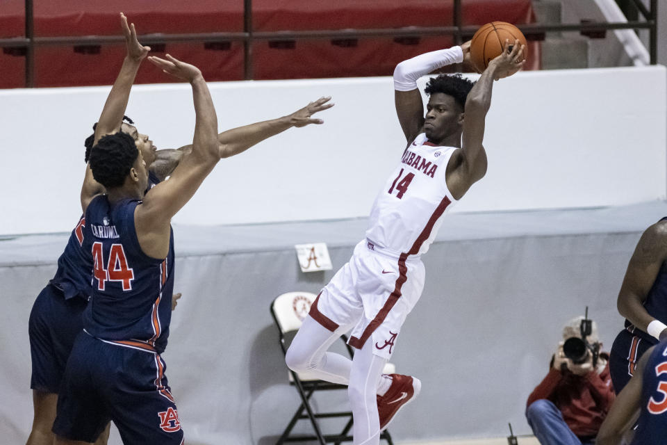 Alabama guard Keon Ellis (14) passes the ball as Auburn center Dylan Cardwell (44) defends during the first half of an NCAA college basketball game Tuesday, March 2, 2021, in Tuscaloosa, Ala. (AP Photo/Vasha Hunt)