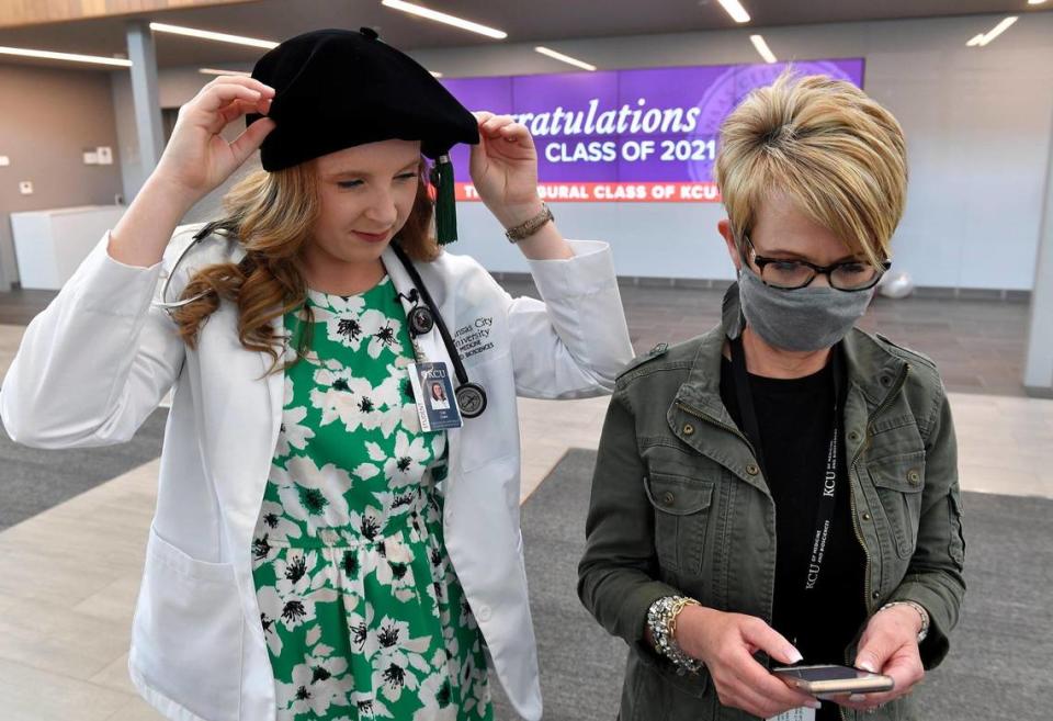 Cali Clark, left, is one of the first graduates of the new Kansas City University school of medicine in Joplin. She stopped by the student center on Friday afternoon to pick up her cap and gown from Haley Reardon, who searched for information on her phone about how to wear the fancy cap.