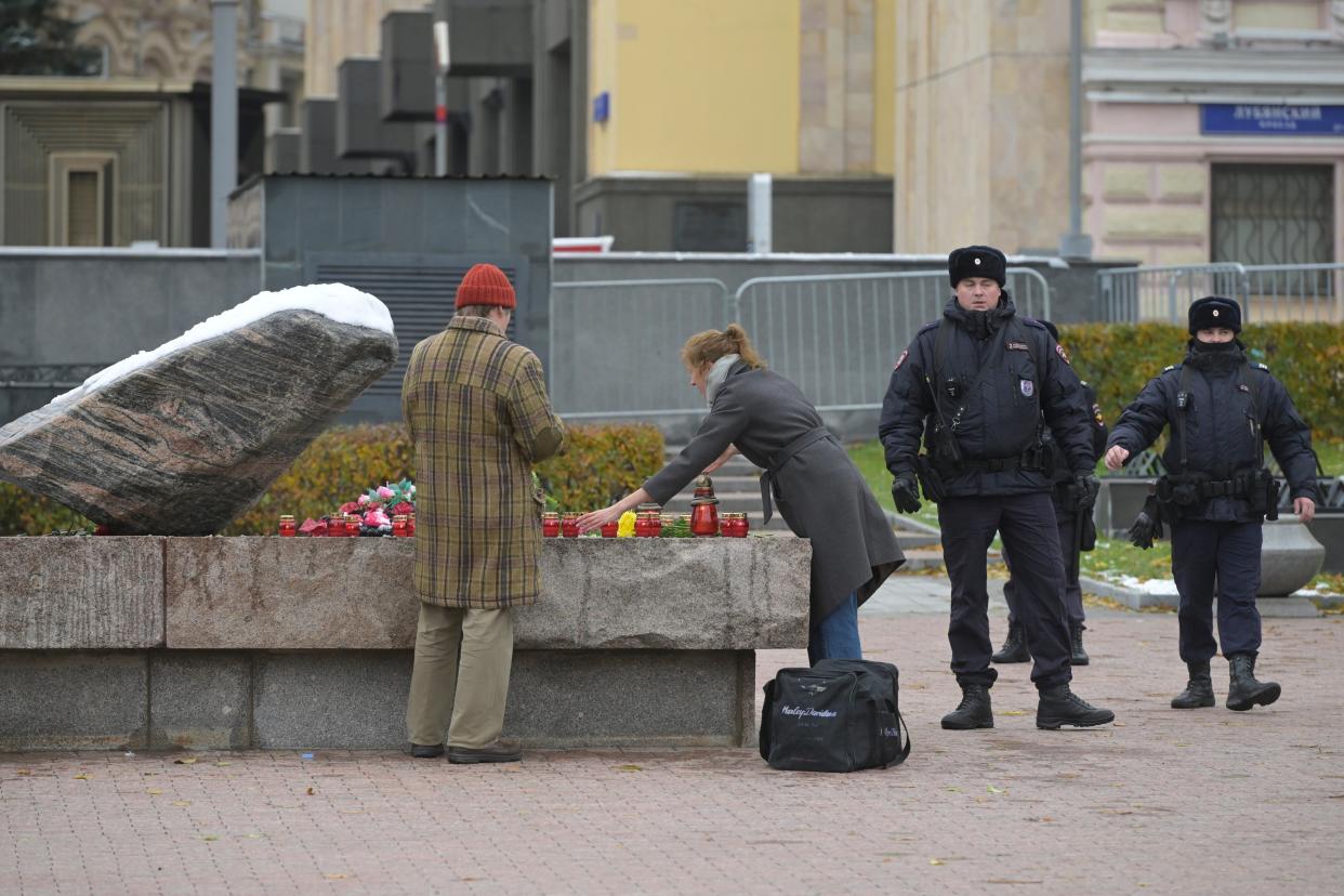 Police officers patrol an area as people lay flowers at the monument, a large boulder from the Solovetsky islands, where the first camp of the Gulag political prison system was established (Copyright 2023 The Associated Press. All rights reserved.)