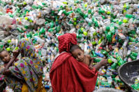 In Bangladesch in Indien sortieren weibliche Tagelöhner unzählige PET-Flaschen, während sie ihre Kinder auf dem Arm tragen. Das Recyceln der Plastikflaschen ist in den letzten Jahren zu einem lukrativen Geschäft in Bangladesch geworden. (Foto: Abir Abdullah/EPA)