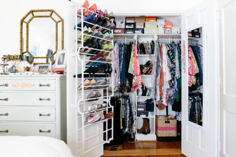 Interior of closet with shoe racks, multiple hanging racks, and shelves