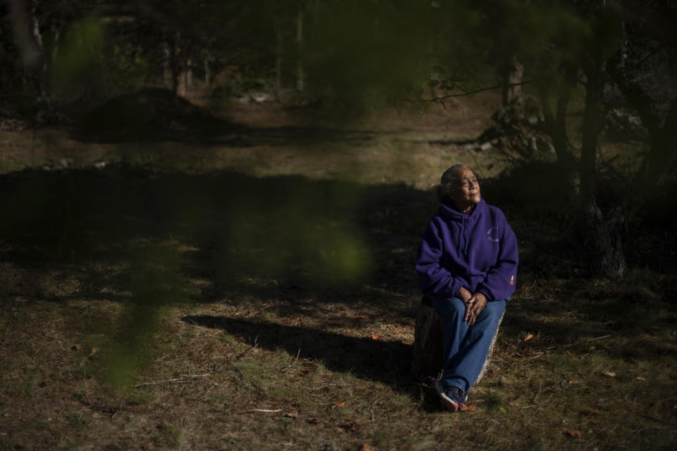 Hazel Harding Currence, 78, a Herring Pond Wampanoag Tribe Elder, sits for a portrait in her backyard in Bourne, Mass., Tuesday, Oct. 6, 2020. "We were exposed to disease. We were exposed to slavery. I mean, what happened here was people who came not just for religion, that might have been their purpose of leaving their homeland, but they came here and wanted to wipe out the existence of a whole culture," said Currence. "We should have never been treated the way that we were, our ancestors," Currence added. "I think that if they were here now, if they were looking down on us, I think they'd be very proud at the movement that's going forward now." (AP Photo/David Goldman)