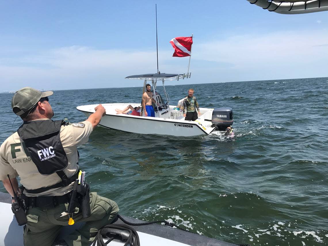 Florida Fish and Wildlife Conservation Commission Officer Guillermo Cartaya asks a diver to board her boat so he could inspect the vessel for any violations Wednesday, July 25, 2018, the first day of the two day lobster miniseason.