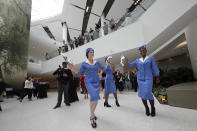 CORRECTS CITY TO KENNER, NOT BATON ROUGE- Women dressed as flight attendants dance and wave handkerchiefs to a second line parade during festivities for the opening of the newly built main terminal of the Louis Armstrong New Orleans International Airport in Kenner, La., Tuesday, Nov. 5, 2019. (AP Photo/Gerald Herbert)