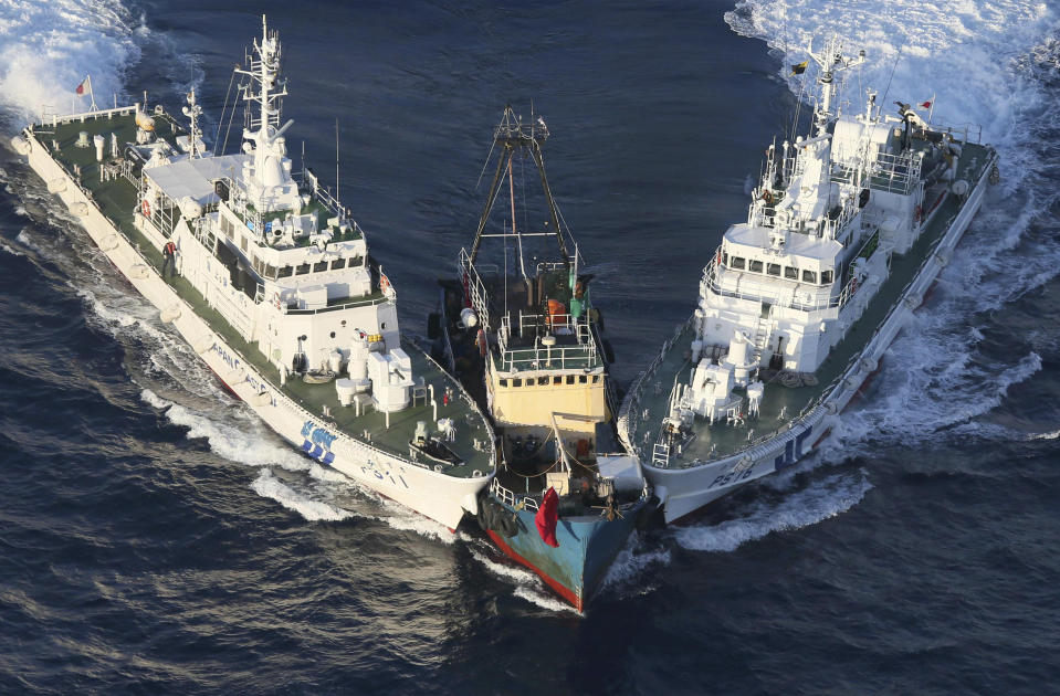 A boat, center, is surrounded by Japan Cost Guard's patrol boats after some activists descended from the boat on Uotsuri Island, one of the islands of Senkaku in Japanese and Diaoyu in Chinese, in East China Sea Wednesday, Aug. 15, 2012. Regional tensions flared on the emotional anniversary of Japan’s World War II surrender as activists from China and South Korea used Wednesday’s occasion to press rival territorial claims, prompting 14 arrests by Japanese authorities. The 14 people had traveled by boat from Hong Kong to the disputed islands controlled by Japan but also claimed by China and Taiwan. (AP Photo/Yomiuri Shimbun, Masataka Morita) JAPAN OUT, MANDATORY CREDIT