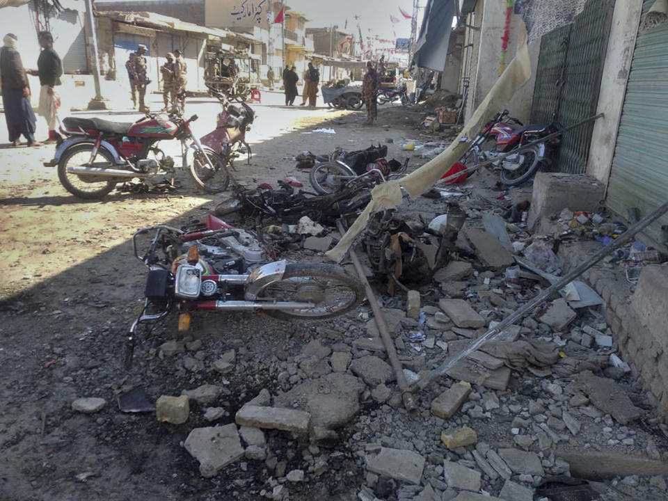 Security officials examine the site of bomb blast in Qillah Saifullah, a town of Pakistan's Baluchistan province, Wednesday, Feb. 7, 2024. A pair of bombings at the election offices of a political party and an independent candidate in southwest Pakistan killed some people and wounded more than two dozen, officials said Wednesday, the day before parliamentary elections are to be held. (AP Photo/Zain Ullah)