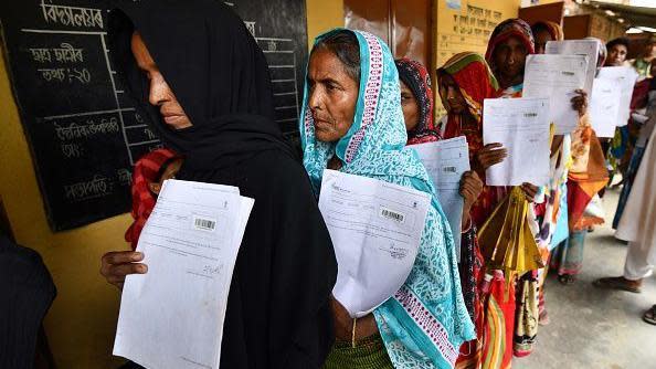 Residents hold their documents as they stand in a queue to check their names on the final list of National Register of Citizens (NRC) at a NRC Sewa Kendra (NSK) in Burgoan village in Morigoan district on July 30, 2018