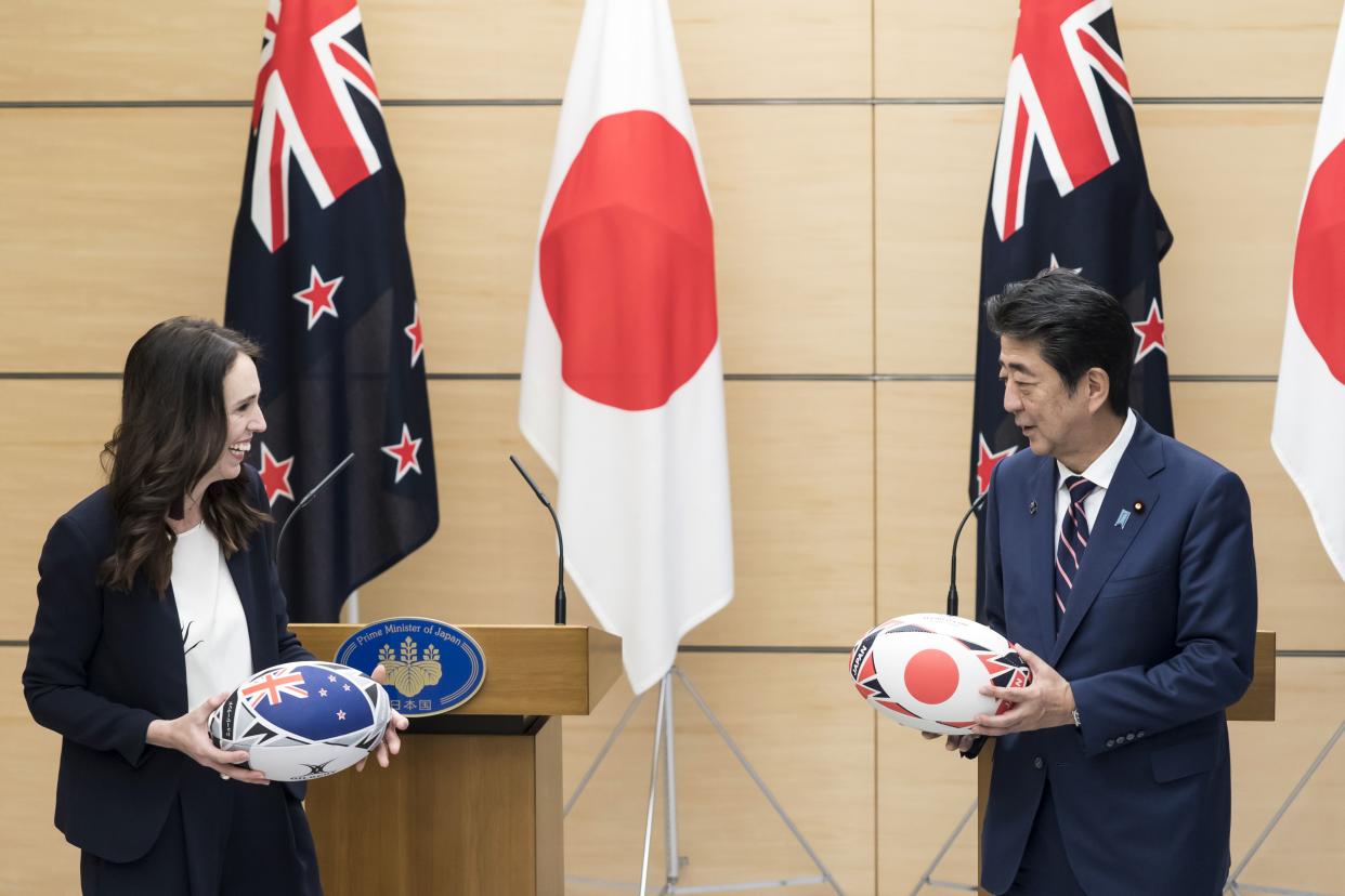 New Zealand's Prime Minister Jacinda Ardern (L) and Japan's Prime Minister Shinzo Abe (R) exchange rugby balls after a joint press conference in Tokyo on September 19, 2019. 