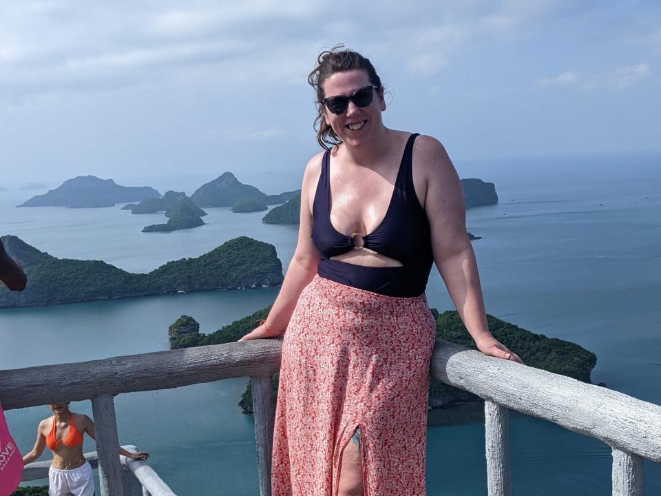 A woman posing at a viewpoint in Thailand with islands in the distance.