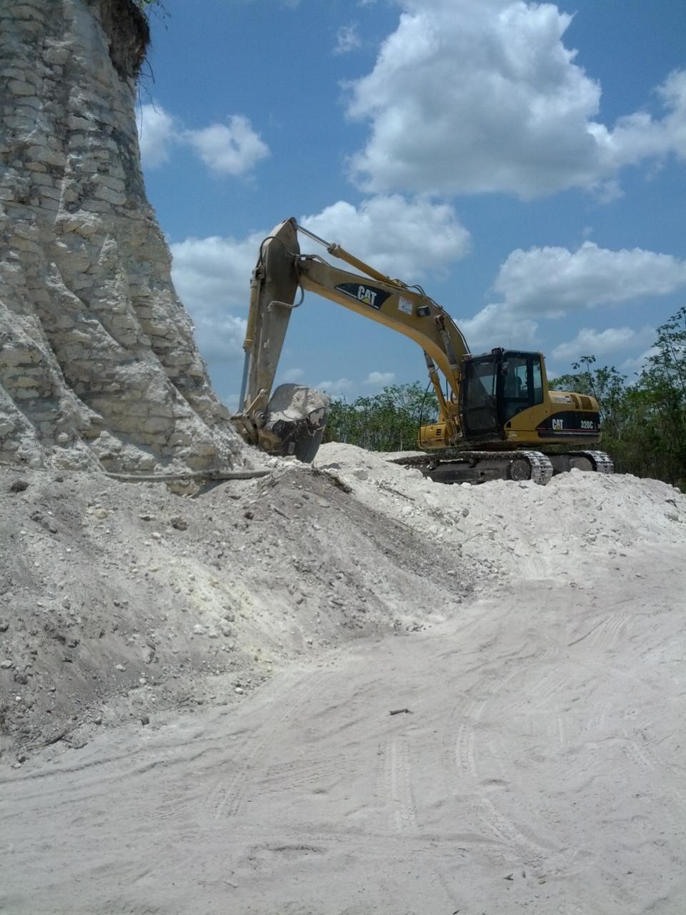 In this image released by Jaime Awe, head of the Belize Institute of Archaeology on Monday May 13, 2013, a backhoe claws away at the sloping sides of the Nohmul complex, one of Belize's largest Mayan pyramids on May 10, 2013 in northern Belize. A construction company has essentially destroyed one of Belize's largest Mayan pyramids with backhoes and bulldozers to extract crushed rock for a road-building project, authorities announced on Monday. (AP Photo/Jaime Awe)