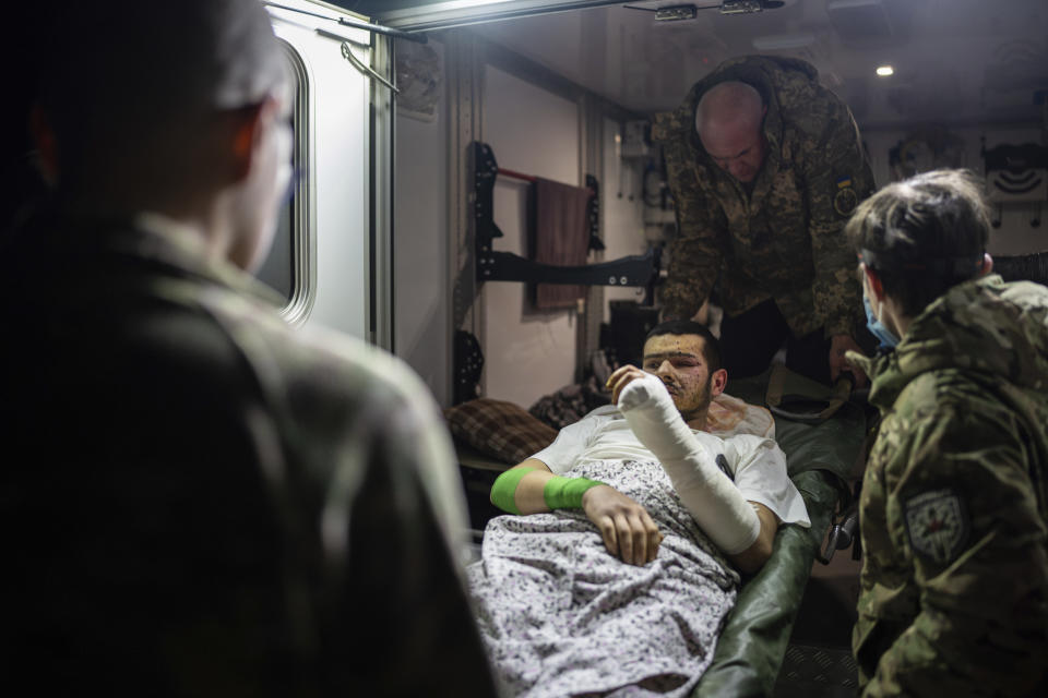 Medics of volunteer battalion "Hospitallers" move injured Ukrainian serviceman Mykola, 25, from ambulance to the medical bus during evacuation to safe area, in Dnipropetrovsk region, Ukraine, on Wednesday, Feb. 28, 2024. (AP Photo/Alex Babenko)