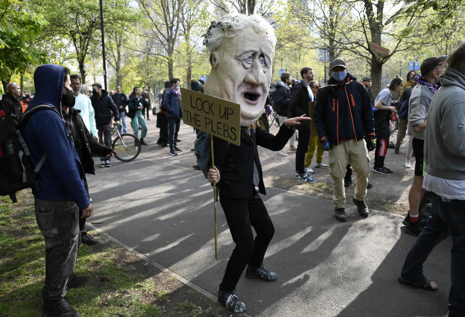 A man wearing a Boris Johnson head during a 'Kill the Bill' protest in central London, Saturday, May 1, 2021. The demonstration is against the contentious Police, Crime, Sentencing and Courts Bill, which is currently going through Parliament and would give police stronger powers to restrict protests. (AP Photo/Alberto Pezzali)