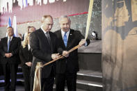 Russian President Vladimir Putin, left, cuts a ribbon with Israeli Prime Minister Benjamin Netanyahu during the dedication of a monument honoring the veterans and victims of the siege of Leningrad in Jerusalem, Thursday, Jan. 23, 2020. Putin, French President Emmanuel Macron, Britain’s Prince Charles, Vice President Mike Pence and the presidents of Germany, Italy and Austria were among the more than 40 dignitaries attending the World Holocaust Forum, which coincides with the 75th anniversary of the liberation of the Auschwitz death camp. (Amit Shabi/Pool Photo via AP)