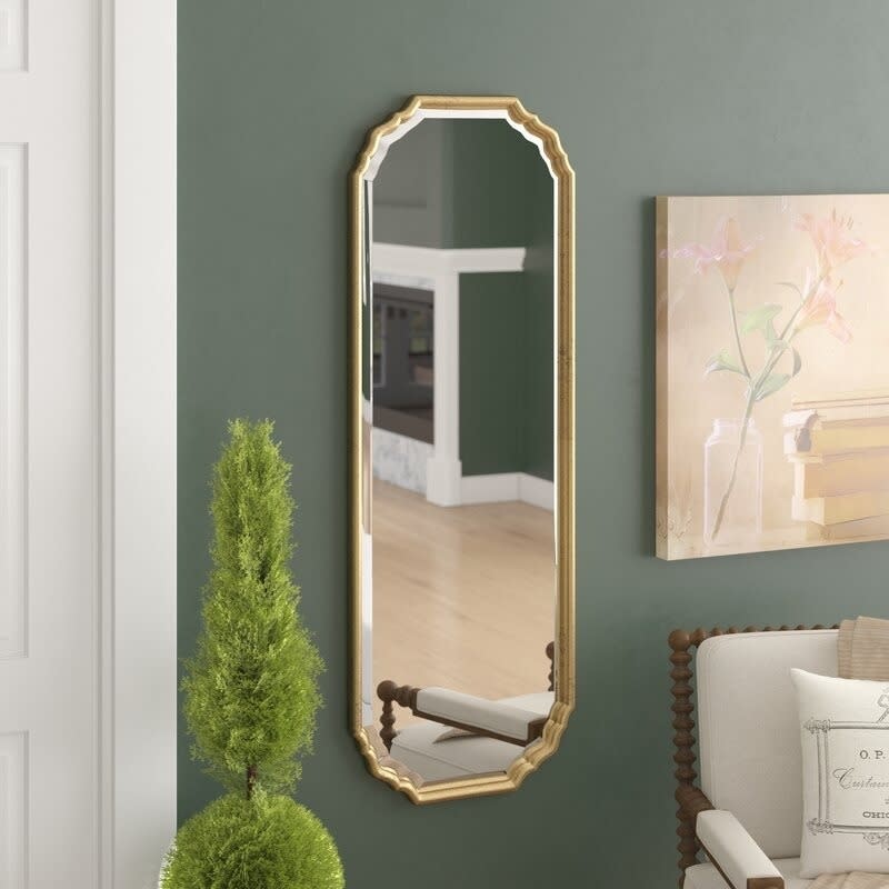 the arched mirror with curved corners hanging in a room