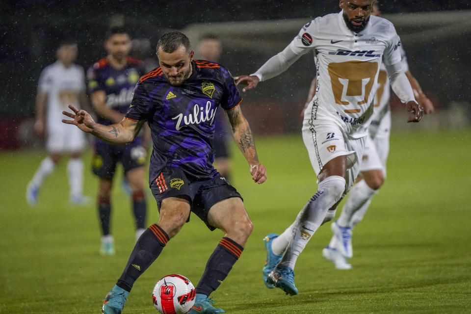 Jordan Morris of United States' Seattle Sounders, left, attempts a shot on goal against Mexico's Pumas during the first leg of the CONCACAF Champions League soccer final, in Mexico City, Wednesday, April 27, 2022. (AP Photo/Marco Ugarte)