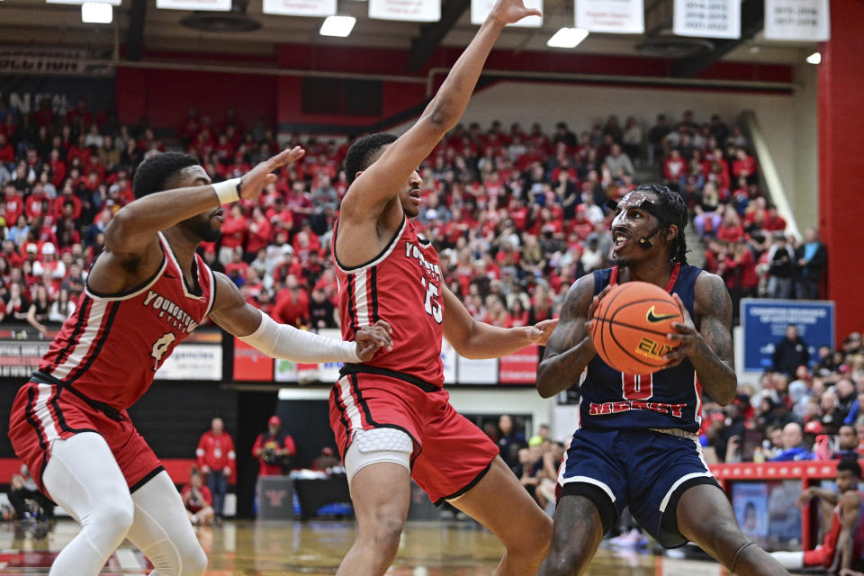 Detroit Mercy guard Antoine Davis, right, looks to shoot while guarded by Youngstown State guards Myles Hunter, center, and Bryce McBride during the first half of an NCAA college basketball game in the quarterfinals of the Horizon League tournament, Thursday, March 2, 2023, in Youngstown, Ohio. (AP Photo/David Dermer)