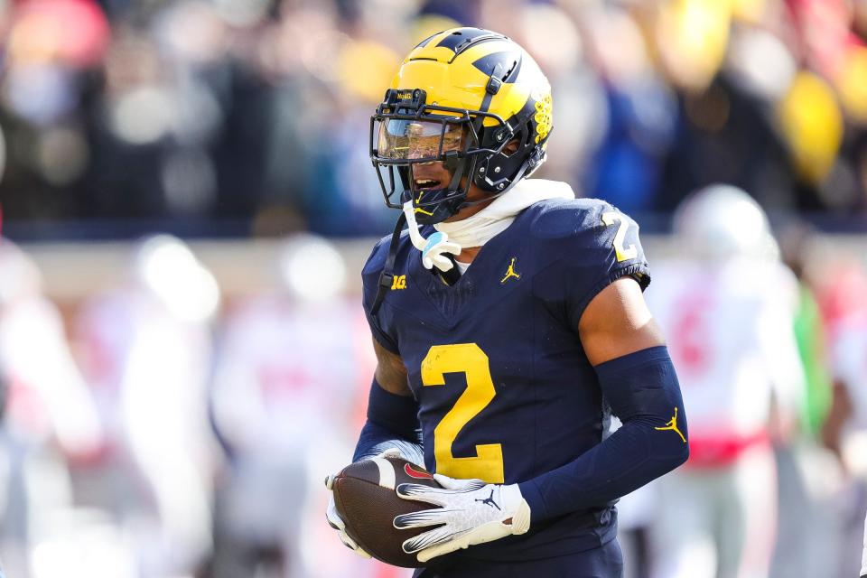 Michigan defensive back Will Johnson (2) reacts after intercepting a pass from Ohio State quarterback Kyle McCord (6) during the first half at Michigan Stadium in Ann Arbor on Saturday, Nov. 25, 2023.