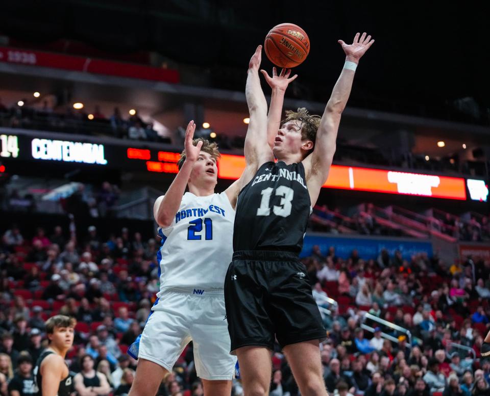 Waukee Northwest guard Pryce Sandfort (21) goes up for a shot against Ankeny Centennial guard Nick Vaske (13) during the class 4A quarterfinal of the Iowa high school boys state basketball tournament.