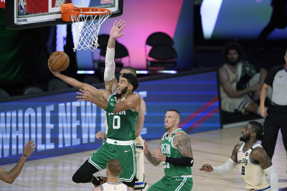 Boston Celtics' Jayson Tatum (0) heads to the basket during the first half of an NBA basketball game against the Milwaukee Bucks Friday, July 31, 2020, in Lake Buena Vista, Fla. (AP Photo/Ashley Landis, Pool)