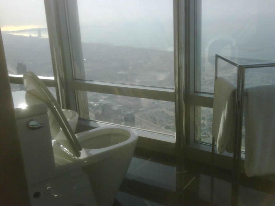 Bathroom with toilet next to floor-to-ceiling windows overlooking expansive view