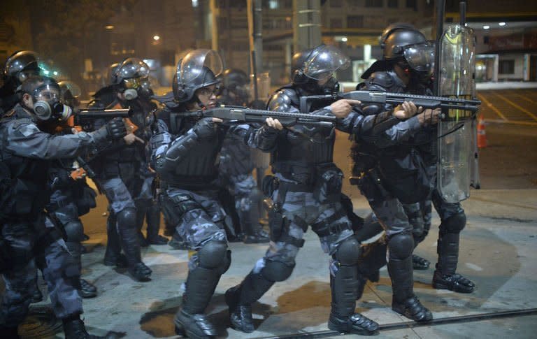 Anti riot police charge during a protest in a street near the Maracana stadium of Rio de Janeiro on June 30, 2013. More than 11,000 police and troops were mobilized to ensure security for 78,000 fans at the Maracana arena