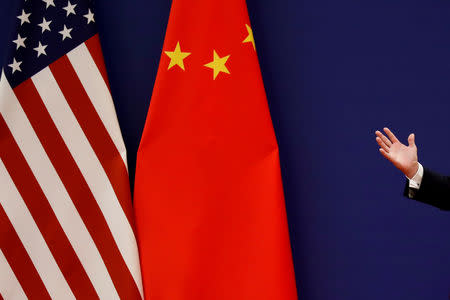 FILE PHOTO: U.S. President Donald Trump delivers his speech next to U.S. and Chinese flags as he and Chinese President Xi Jinping meet business leaders at the Great Hall of the People in Beijing, China, November 9, 2017. REUTERS/Damir Sagolj/File Photo